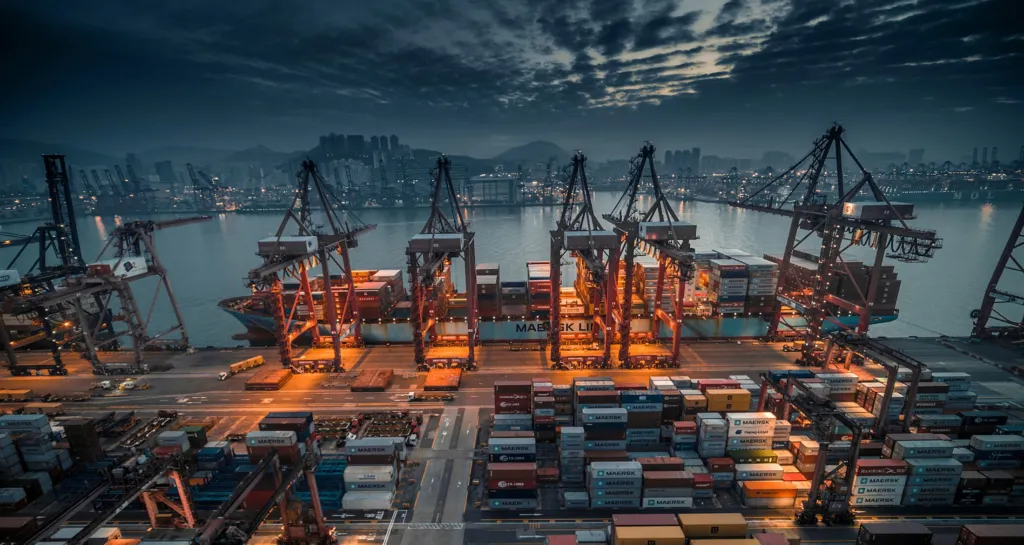 Port cranes loading a vessel at night